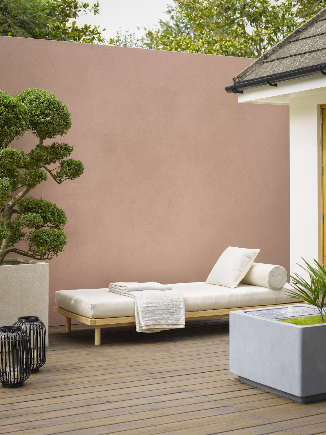 Outdoor decking with patio furniture on top as well as a plant pot and candle holders