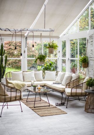 sunroom with rattan furniture grey flooring hanging plants