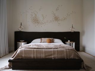 serene bedroom with black headhead and natural linen colored sheets