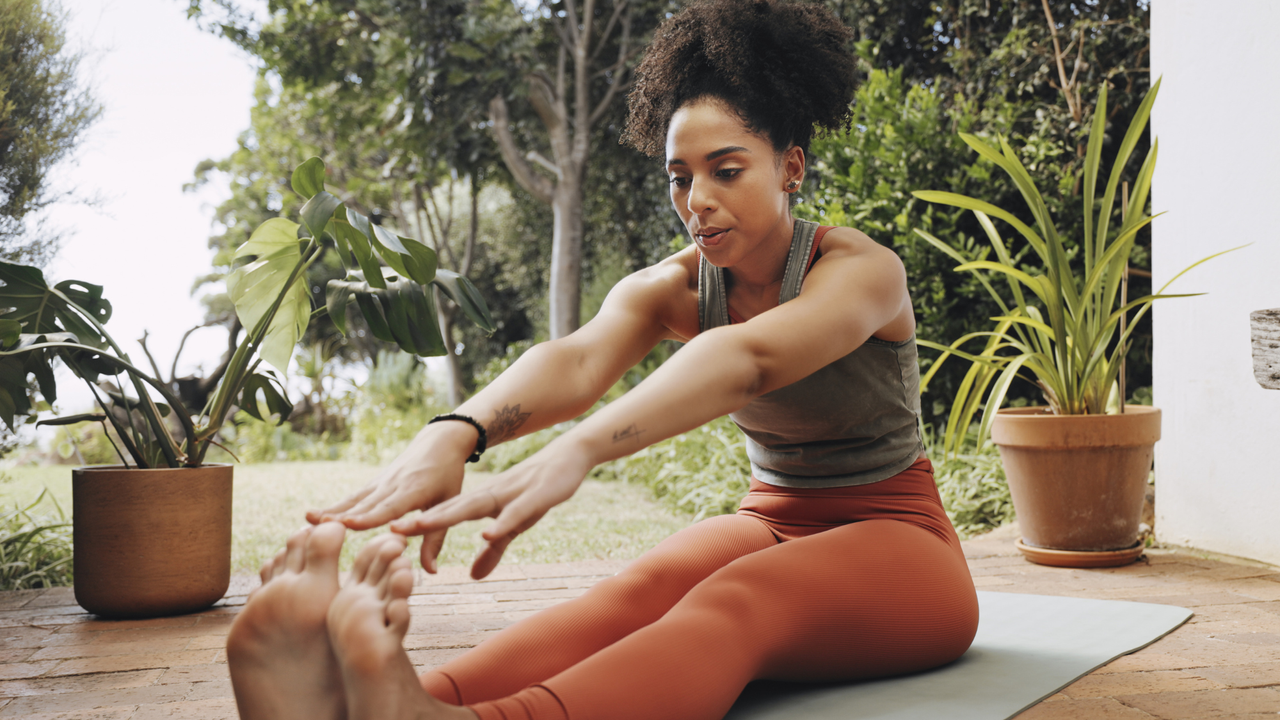 A woman touching her toes during a home workout for beginners