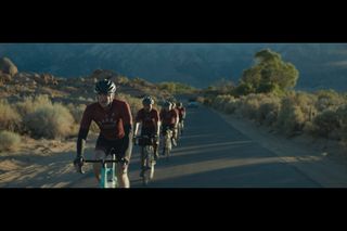 Actor Matthew Modine wears a red long sleeved cycling jersey as he leads a paceline through the desert in the film Hard Miles