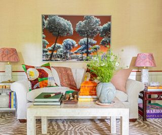 Colorful living room with patterned pillows, beige sofa, tree wall art and zebra print rug