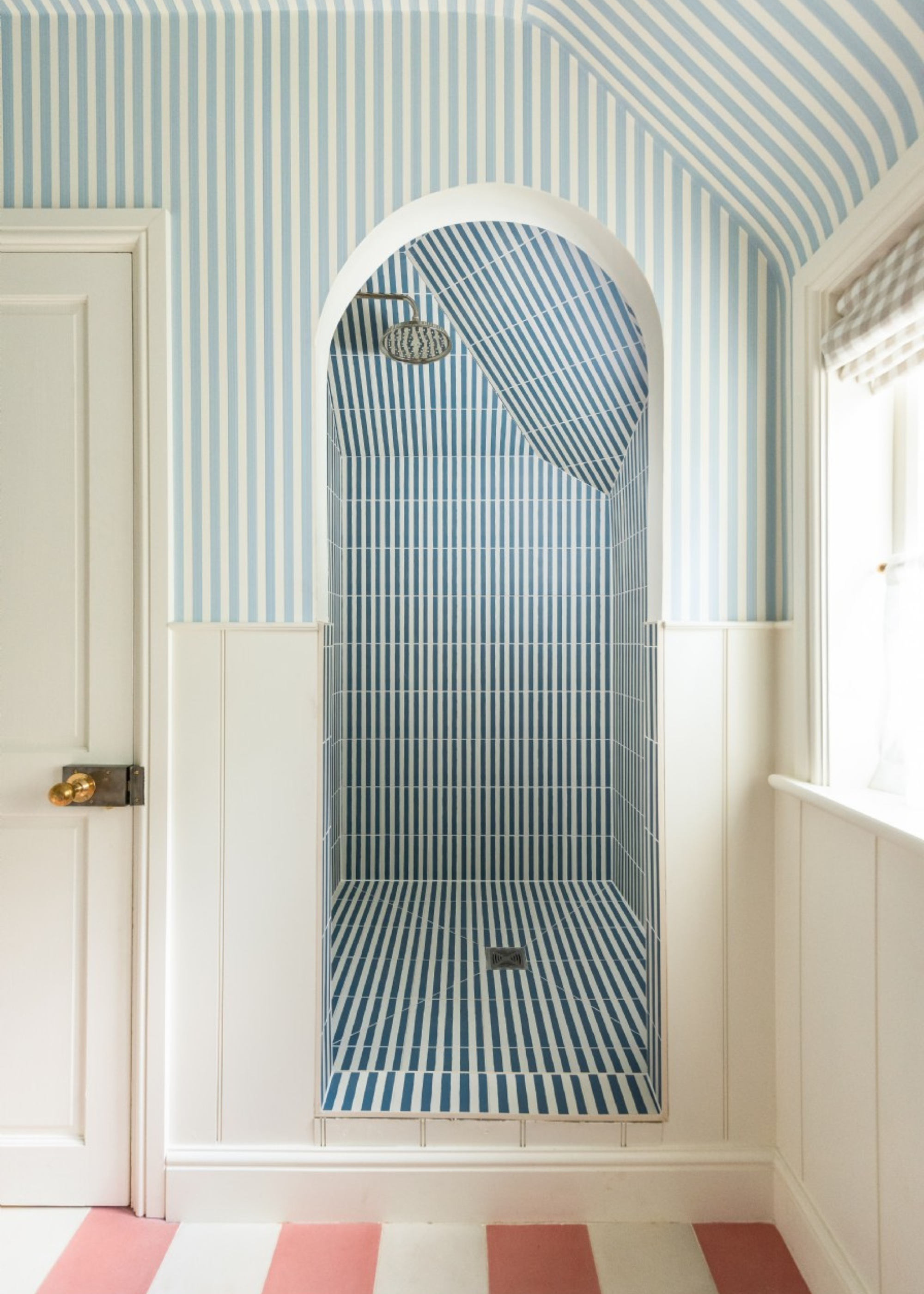 a striped shower room with striped floors and wallpaper and striped tiles in the shower