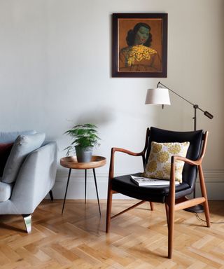 A mid-century modern living room with herringbone flooring, wooden chair and Scandi influence.