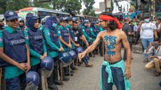 A protester confronts Bangladeshi police in Dhaka amid growing violence