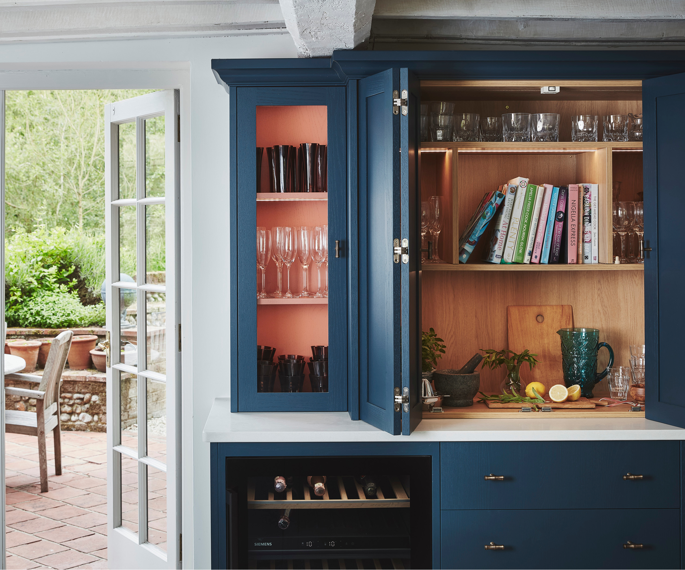 kitchen cabinets with variety of cabinets configured into space for glasses, wine, recipe books and preparation area