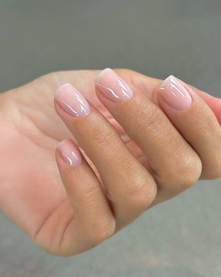 A hand featuring a pale pink manicure