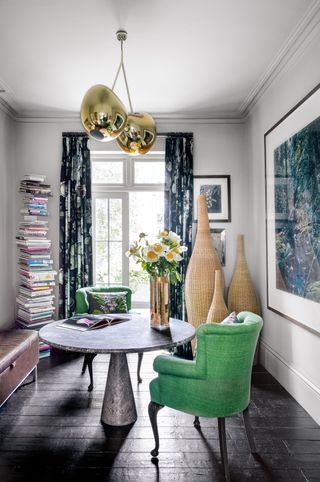 Home office with central circular table and green chairs
