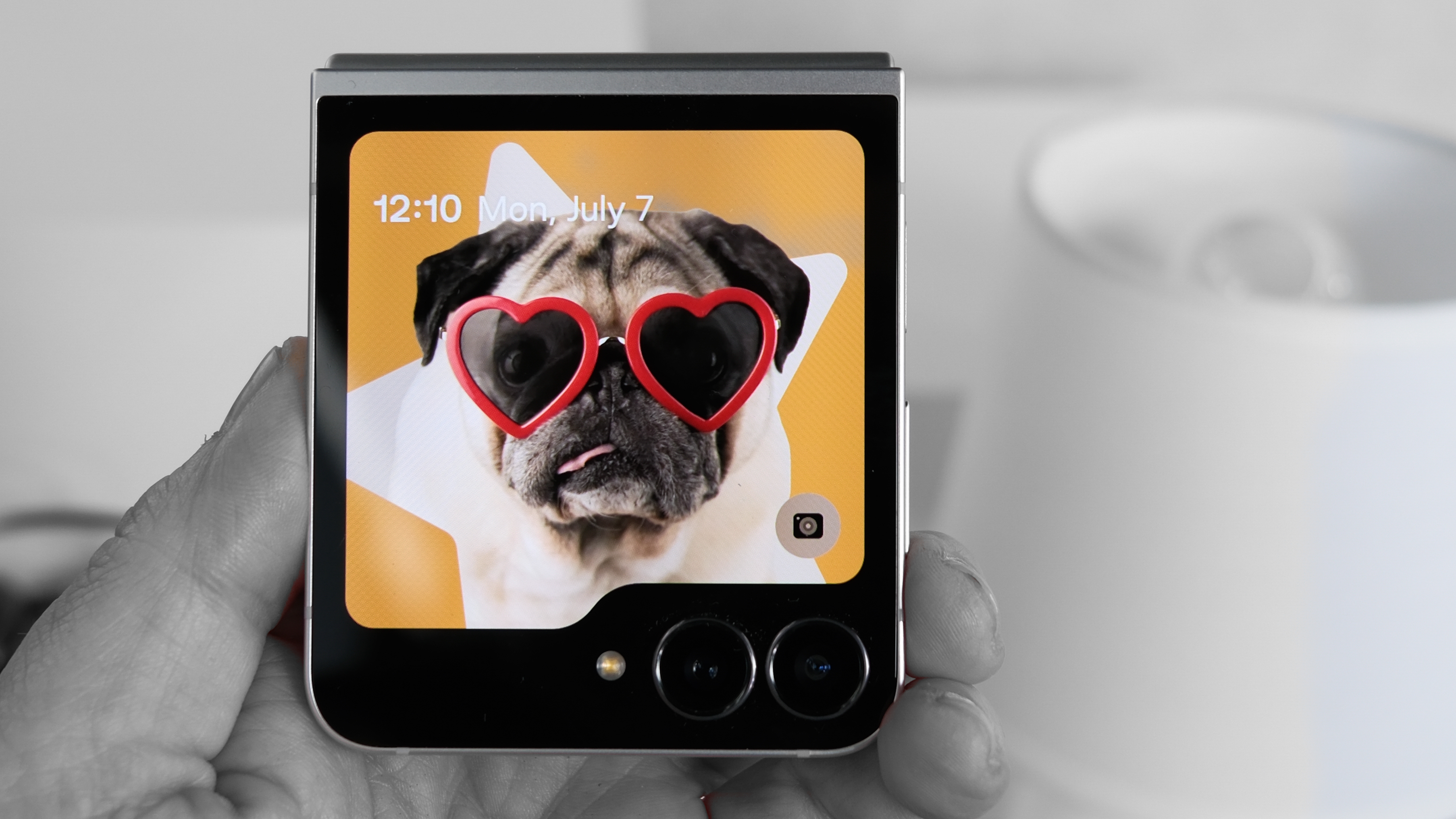 Samsung Galaxy Z Flip 7 FE in black with a color photo of a pug wearing heart shaped glasses on the cover display