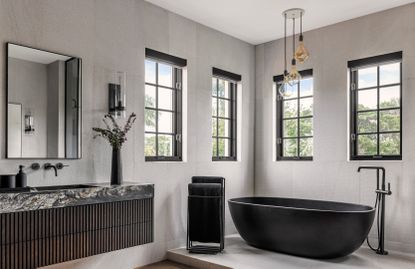 A bathroom with a long pendant above the bathtub