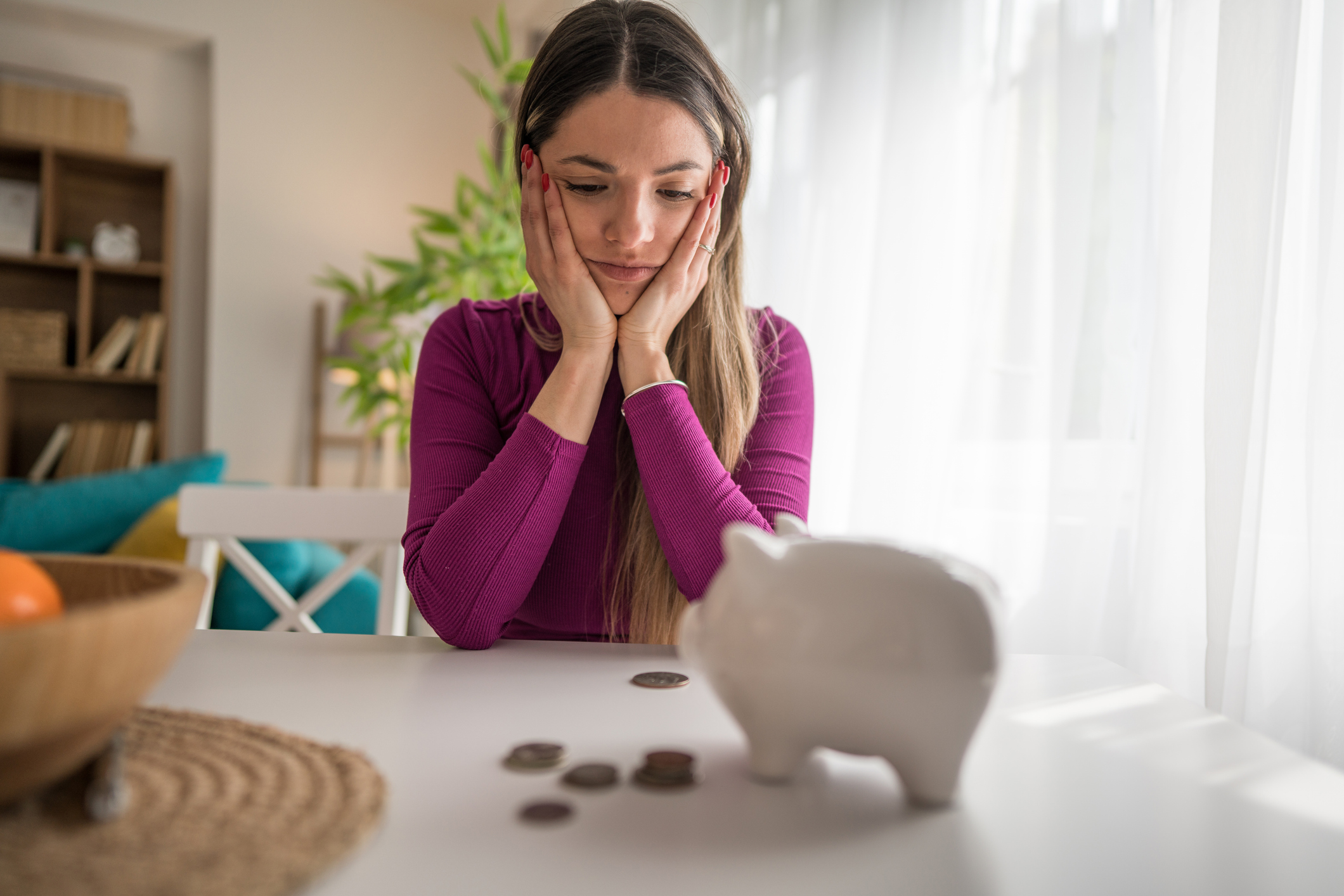 Woman looking at a piggy bank