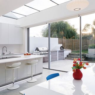 kitchen with white marble platform and table with red flower pot