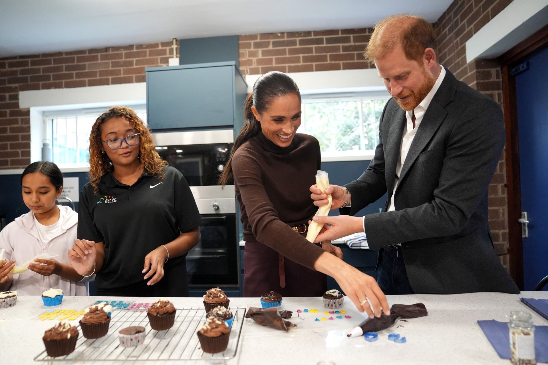 Prince Harry and Meghan Markle decorating cupcakes