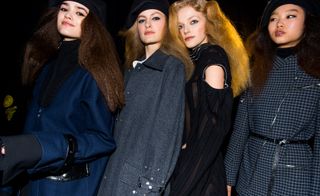 Models are seen wearing dark-coloured outerwear, some have cut-out shoulders and silver bead embellishments