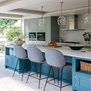 kitchen with blue cabinets grey chairs and white counter