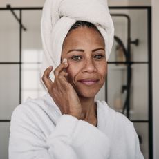 Best serum for pigmentation - woman applying a cream to her skin - getty images 1466780678 