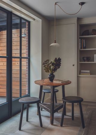 The family room in a New York house with glass panelled doors and antique wooden furniture