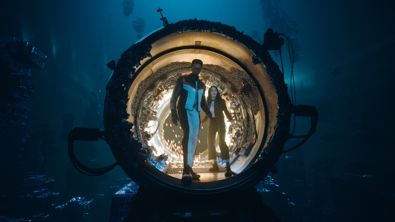 Edi Gathegi and Rachel Brosnahan stand curiously in a portal to the pocket universe in Superman.
