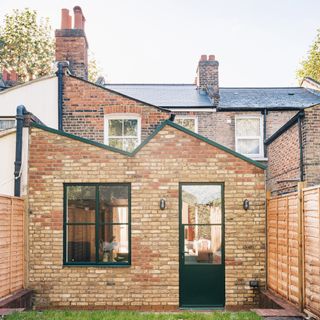 exterior of a kitchen extension with pitched roof and green detailing