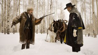 Beste Quentin Tarantino-filmer: En mann peker et gevær mot en annen mann i snøen i filmen The Hateful Eight