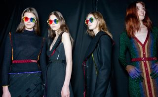 four female models wearing black dress with bright coloured details and rainbow sunglasses