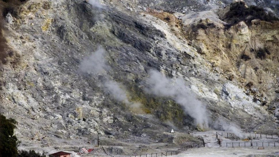 A baron looking landscape with fumes rising from rocks. 