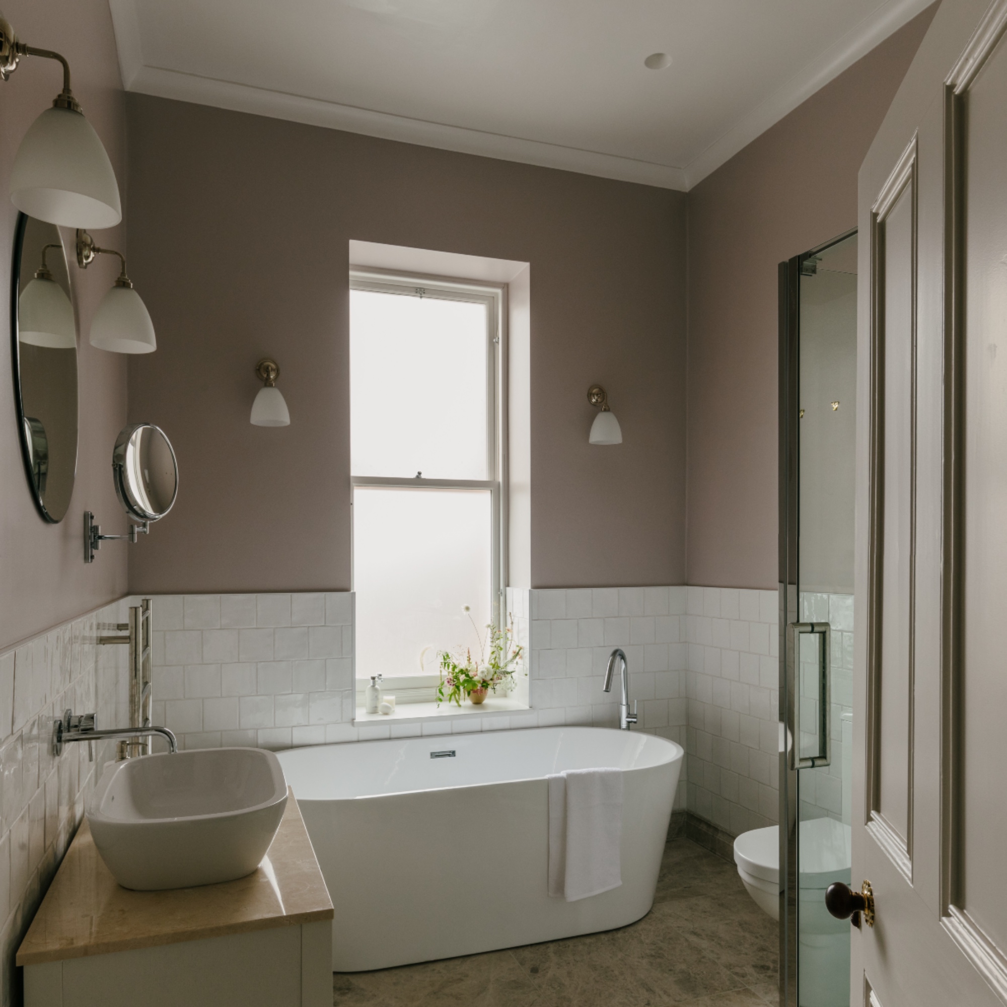 pink and white bathroom with wall lights, white tiles, vanity unit