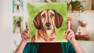 best ways to memorialize your pet — person holding painting of dog