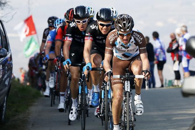 The peloton crests a hill