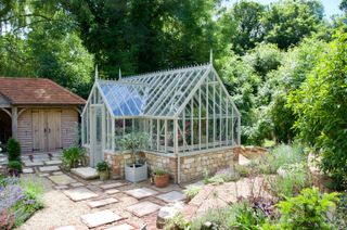 large greenhouse in a traditional cottage style garden