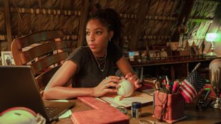 Jessica Williams looks worried sitting behind a cluttered desk in Road House.
