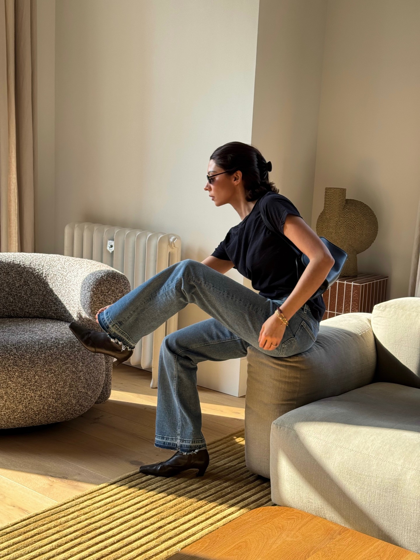 A woman wears frayed jeans and a tee.