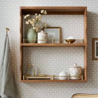 A brown square wall shelf unit with brass tails on the edge of the shelves.