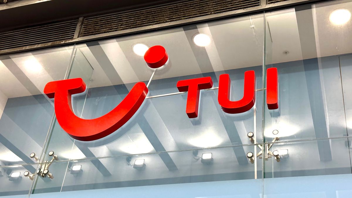 Telephoto shot of the TUI logo on a glass wall. Decorative: the TUI logo is the word &#039;TUI&#039; next to a stylized smile, in red.