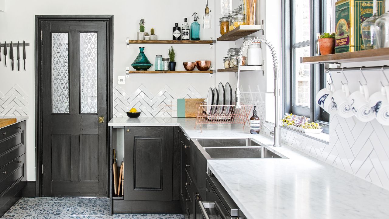 modern black kitchen with white tiles and surfaces and stainless steel sink