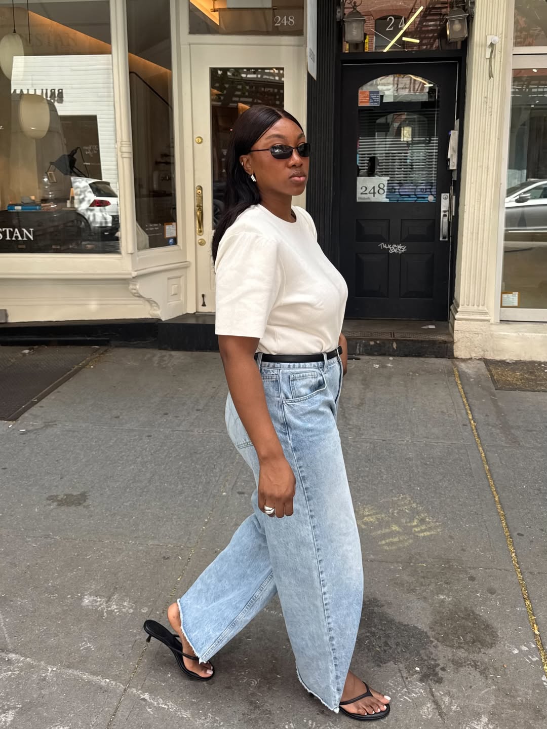 Nnenna in minimal black heeled flip-flops