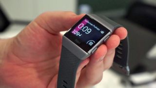Beste Fitbit: En hånd som holder en grå utgave av Fitbit Ionic med skjermen aktivert.
