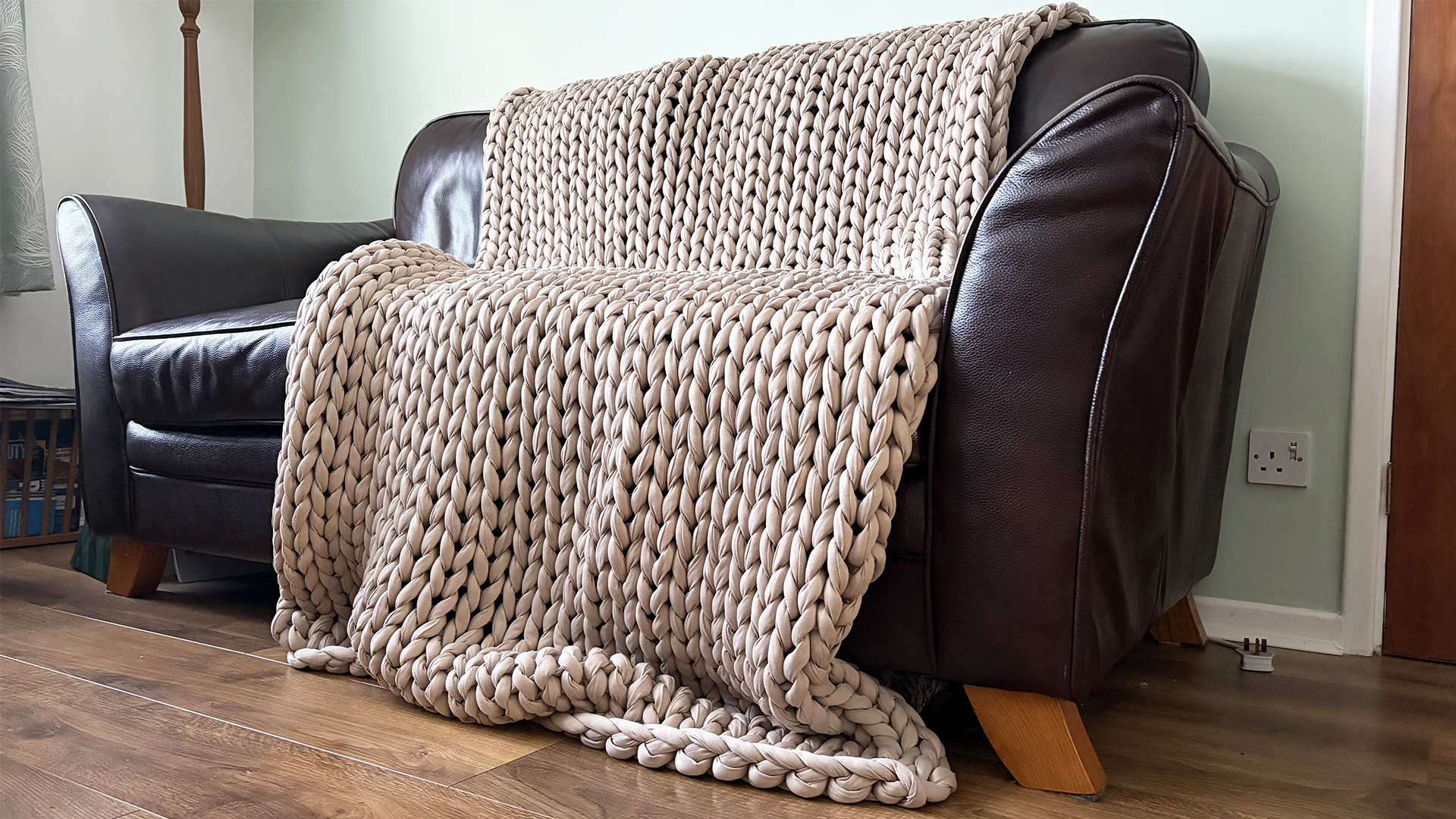 The Bearaby Tree Napper weighted blanket draped across the sofa in our reviewer's home