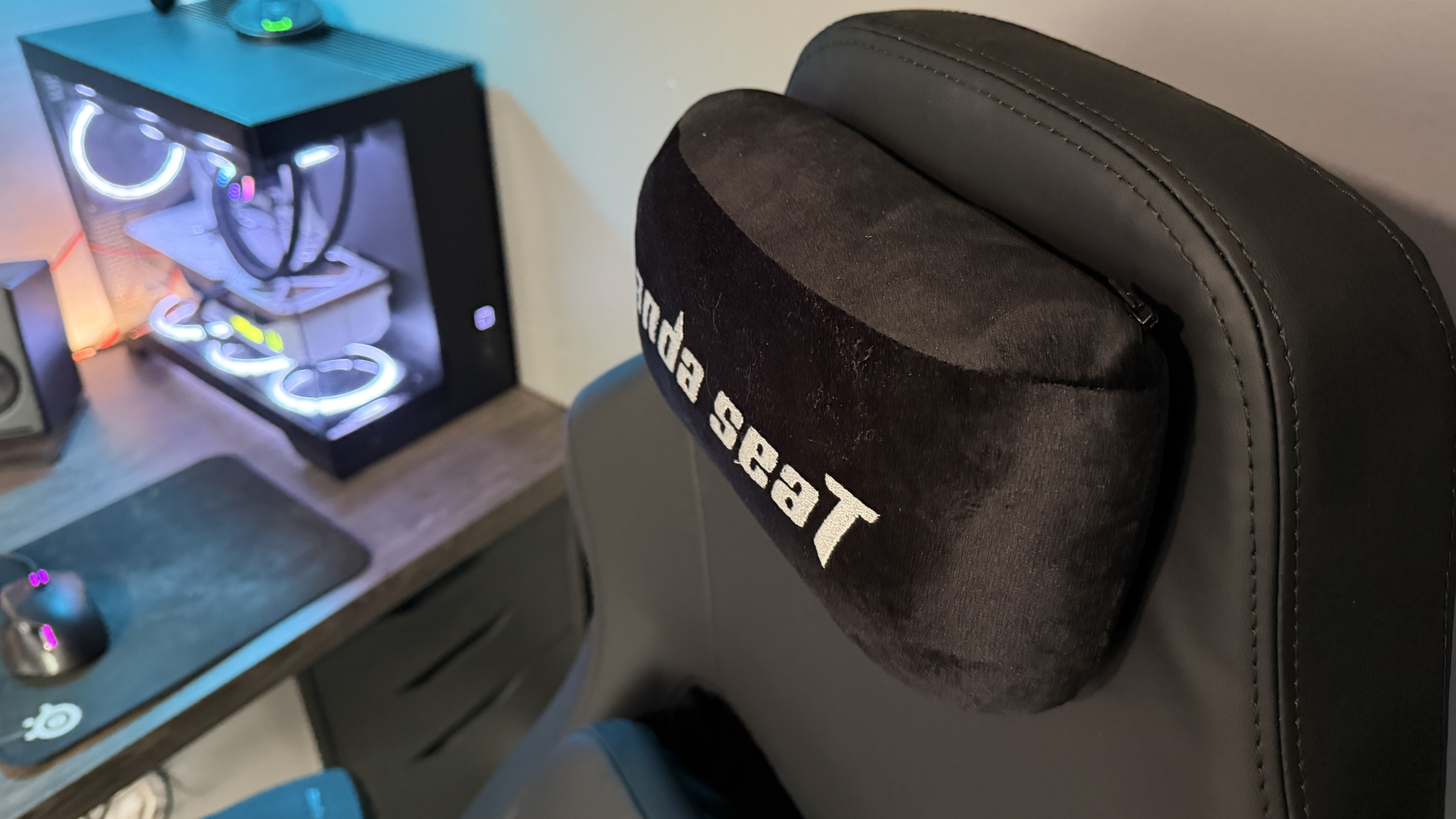 The AndaSeat Phantom 4 Pro in a brightly lit home office environment in front of a gaming PC.
