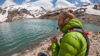 Male trail runner drinks from hydration bladder