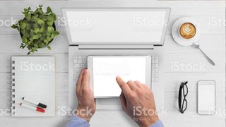 Blank laptop and tablet with man tapping screen