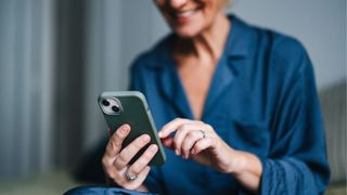 Woman holding phone in hand, smiling