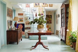 hallway with gallery wall, painted floor and stairs in Vanessa Arbuthnott's converted cow byre home