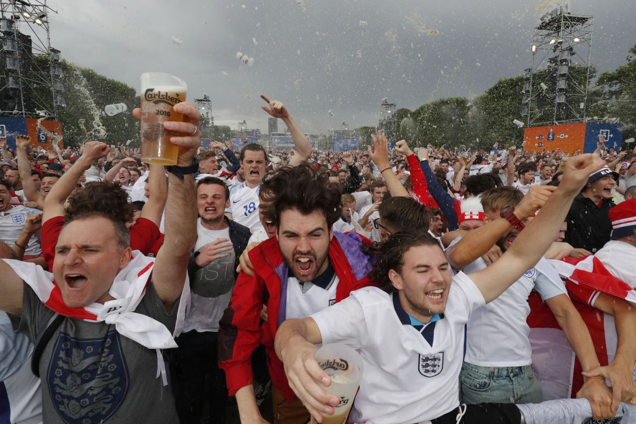 England fans hold glasses of beer while reacting after their team scores goal as they watch the England v Wales EURO 2016 Group B soccer match.