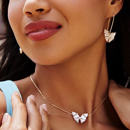 Woman wearing butterfly necklace from Kendra Scott