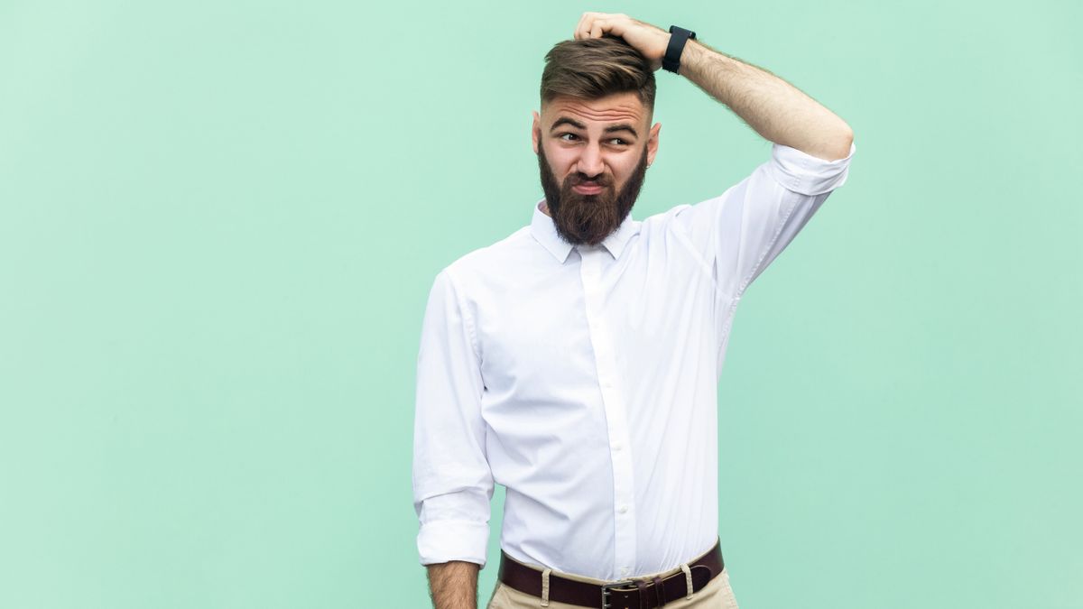 A man with a confused expression scratching his head.