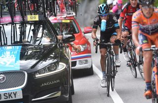 Richie Porte drops back to the car for a bidon
