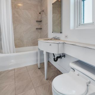 Bathroom with white walls and western commode