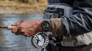 A photo of the Garmin Instinct 3 AMOLED on a man's wrist as he fishes