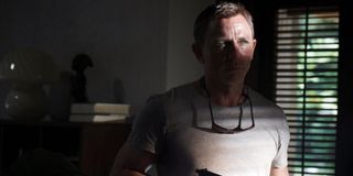 No Time To Die Daniel Craig cautiously arms himself in the shadows